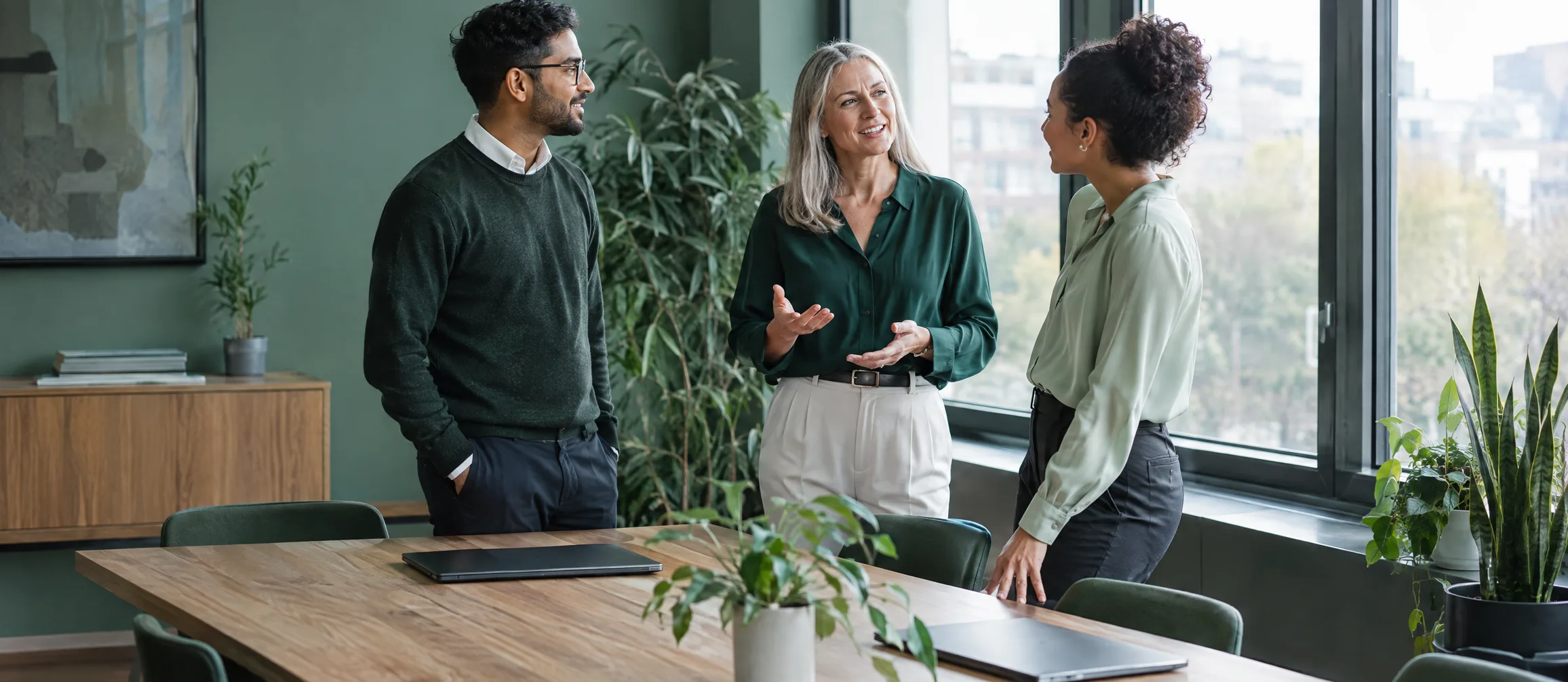 Three of the Ledgerwell team talking around the office table